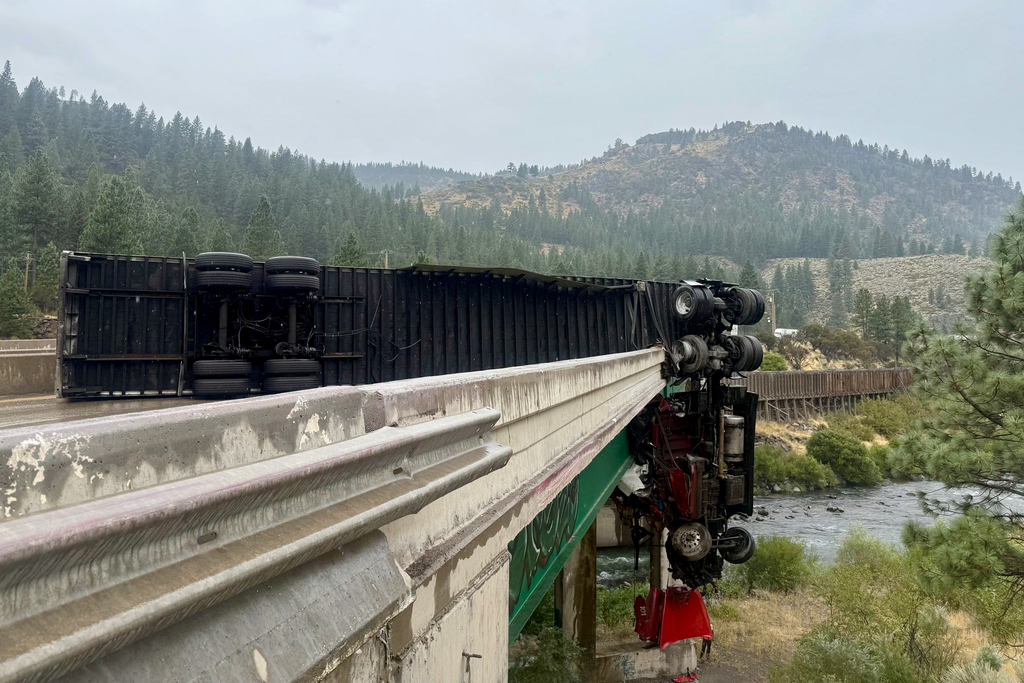 Big rig crashes through I-80 railing, cab left dangling over bridge
